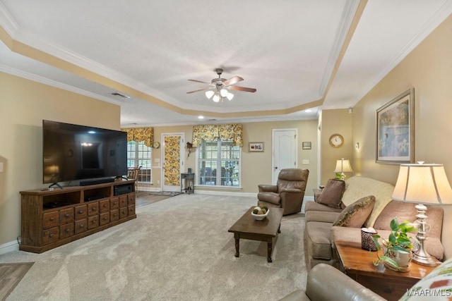 carpeted living area featuring crown molding, a ceiling fan, baseboards, and a tray ceiling