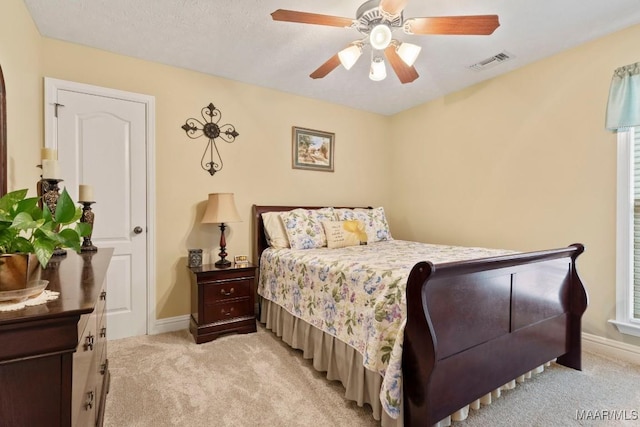 bedroom featuring visible vents, a ceiling fan, baseboards, and light colored carpet