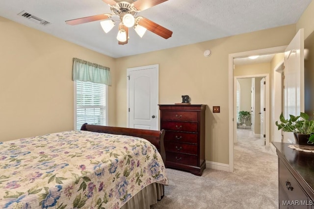 bedroom with light colored carpet, baseboards, visible vents, and ceiling fan