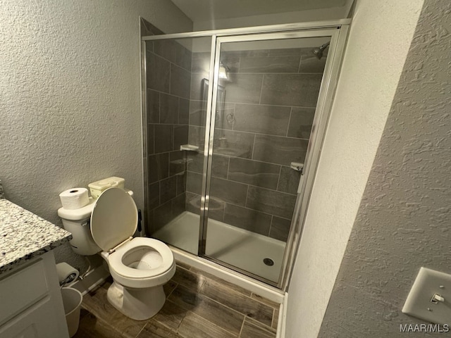 107 Jules Ln, Ashford, AL 36312 - bathroom with a textured wall, vanity, a stall shower, toilet, and wood finished floors