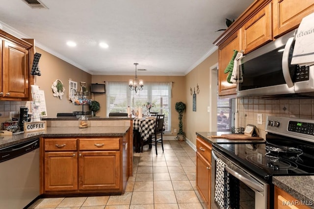 177 Old Orchard Loop, Deatsville, AL 36022 - kitchen with stainless steel appliances, a chandelier, brown cabinetry, backsplash, and a peninsula