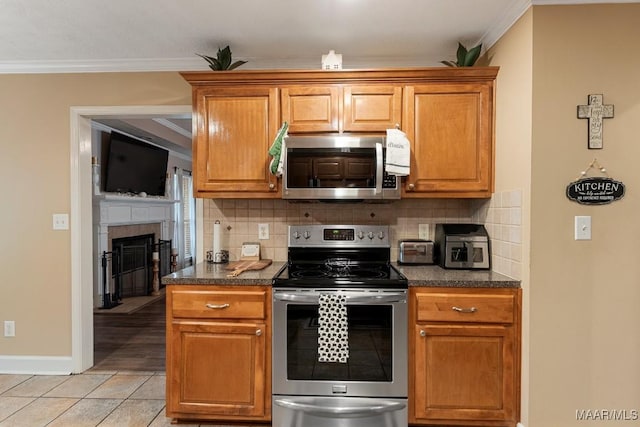 177 Old Orchard Loop, Deatsville, AL 36022 - kitchen featuring appliances with stainless steel finishes, ornamental molding, dark countertops, backsplash, and baseboards