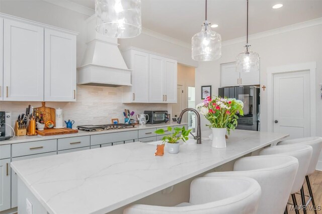8307 Young Xing, Montgomery, AL 36116 - kitchen with stainless steel gas stovetop, tasteful backsplash, a kitchen island with sink, and a toaster