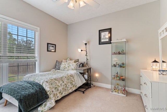 bedroom featuring a ceiling fan, baseboards, and light colored carpet