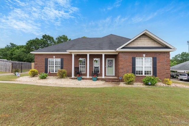 single story home featuring fence, a front lawn, and brick siding