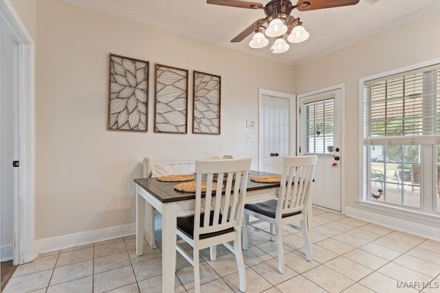 dining space featuring baseboards, ornamental molding, ceiling fan, and light tile patterned floors