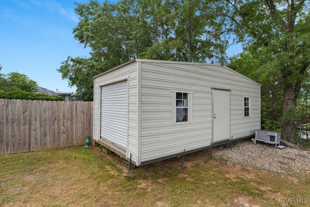 view of outbuilding with fence and an outbuilding
