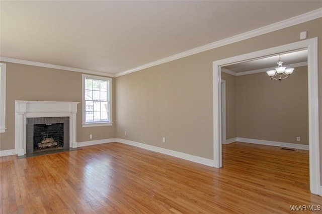 1943 Gorgas St, Montgomery, AL 36106 - unfurnished living room featuring crown molding, a notable chandelier, light wood finished floors, a fireplace, and baseboards
