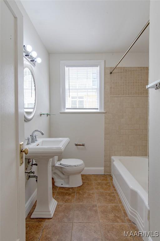 1943 Gorgas St, Montgomery, AL 36106 - full bathroom with tile patterned floors, baseboards, toilet, and a wealth of natural light