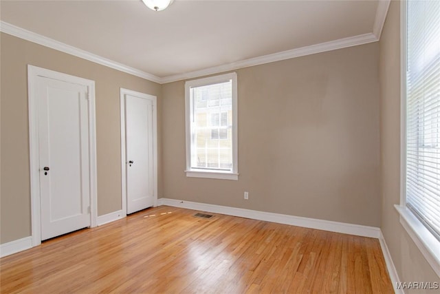 1943 Gorgas St, Montgomery, AL 36106 - unfurnished bedroom with crown molding, multiple windows, light wood-style flooring, and visible vents