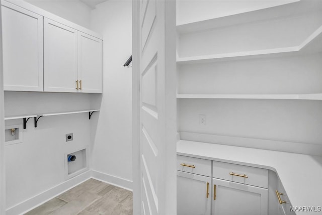 4831 Clerkenwell St, Montgomery, AL 36116 - clothes washing area with electric dryer hookup, cabinet space, baseboards, and washer hookup