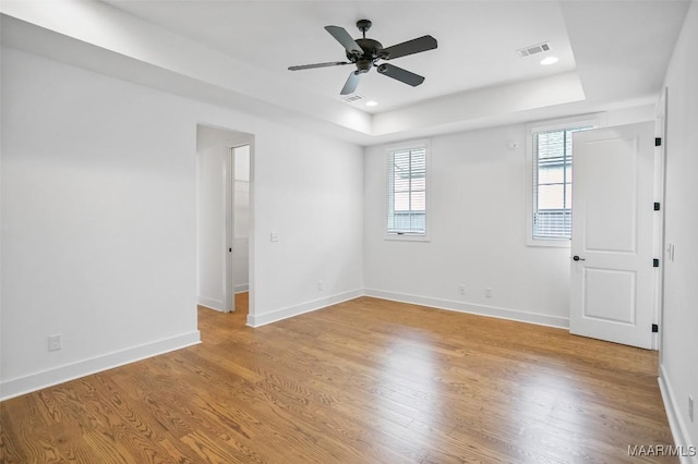 4831 Clerkenwell St, Montgomery, AL 36116 - empty room featuring baseboards, a ceiling fan, a tray ceiling, and light wood-style flooring