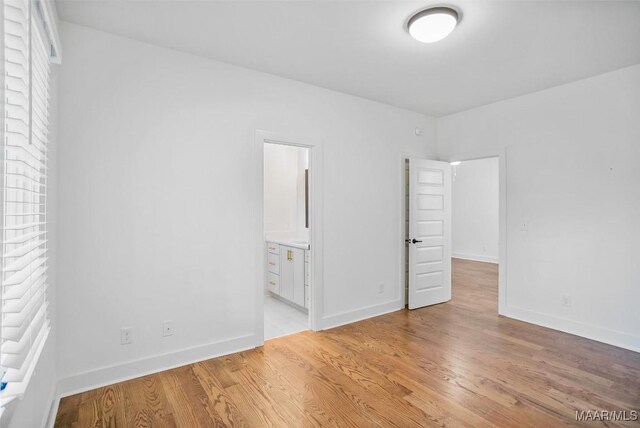 4831 Clerkenwell St, Montgomery, AL 36116 - unfurnished bedroom with baseboards, connected bathroom, and light wood-style flooring