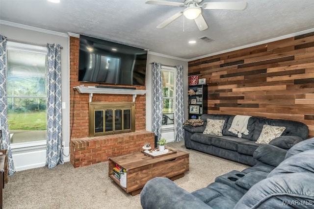 living area with a fireplace, carpet, a ceiling fan, visible vents, and ornamental molding