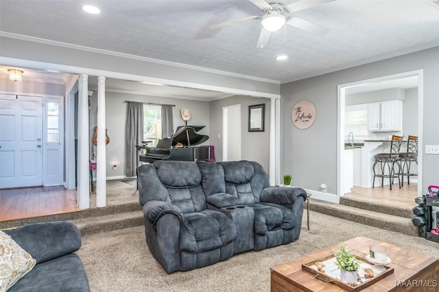 carpeted living area featuring ceiling fan, a sink, recessed lighting, baseboards, and ornamental molding