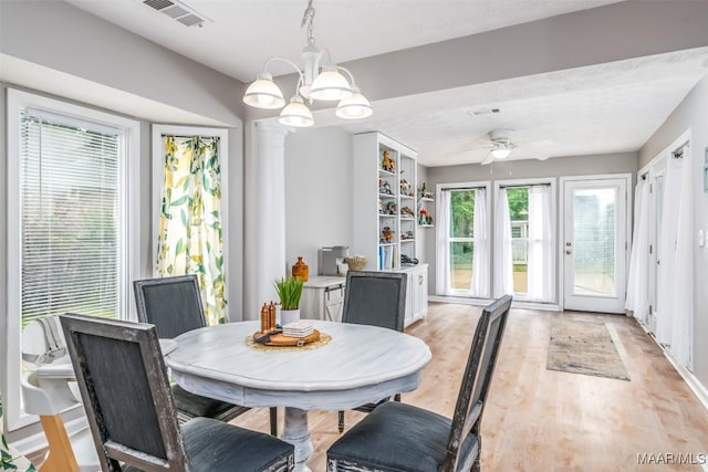 dining room featuring visible vents, light wood-style floors, and ceiling fan with notable chandelier