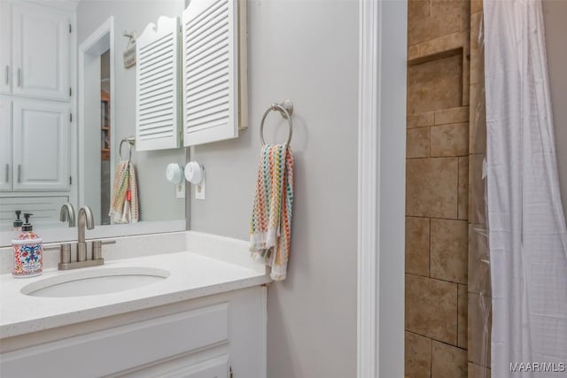 bathroom with vanity and tiled shower