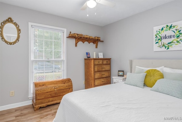 bedroom featuring baseboards, ceiling fan, and light wood-style floors