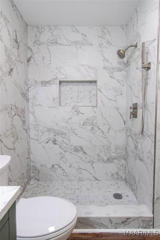 full bath featuring vanity, a stall shower, and toilet