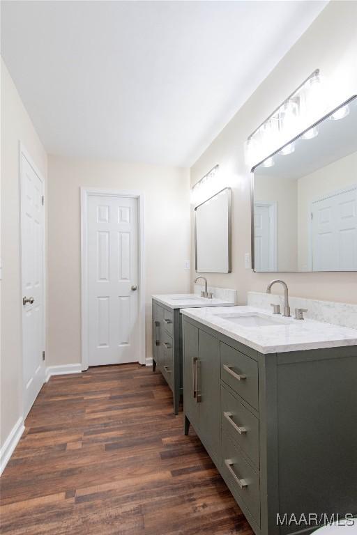 bathroom featuring baseboards, wood finished floors, and vanity