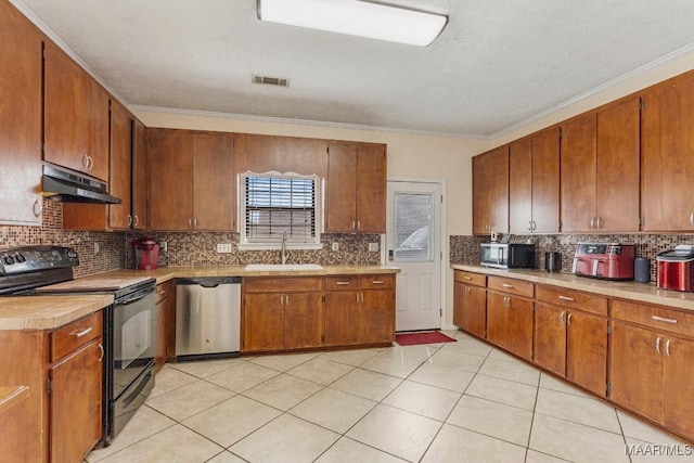 kitchen featuring visible vents, under cabinet range hood, brown cabinets, a sink, and stainless steel appliances