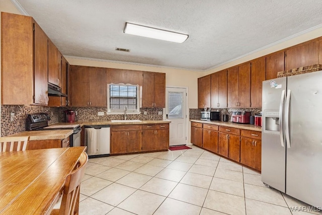 kitchen featuring backsplash, visible vents, appliances with stainless steel finishes, a sink, and under cabinet range hood