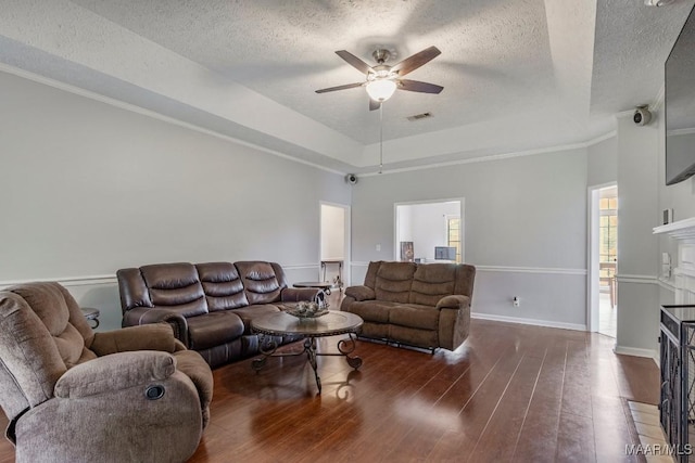 living area featuring a fireplace with flush hearth, a ceiling fan, a textured ceiling, and wood finished floors
