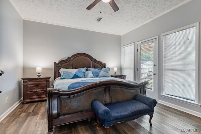 bedroom with dark wood-style flooring, a textured ceiling, visible vents, and access to exterior