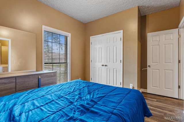 bedroom featuring a textured ceiling, a closet, and wood finished floors