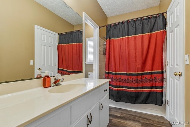 full bathroom with a shower with curtain, a textured ceiling, wood finished floors, and vanity