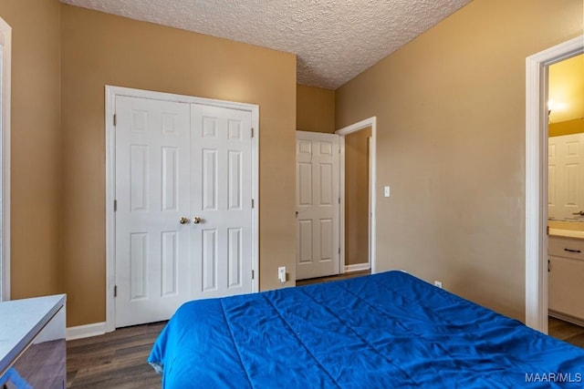 bedroom featuring a closet, baseboards, a textured ceiling, and dark wood-type flooring
