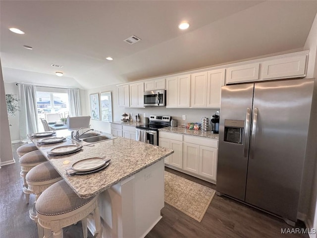 178 Canal Xing, Wetumpka, AL 36092 - kitchen featuring appliances with stainless steel finishes, a sink, vaulted ceiling, dark wood finished floors, and white cabinetry