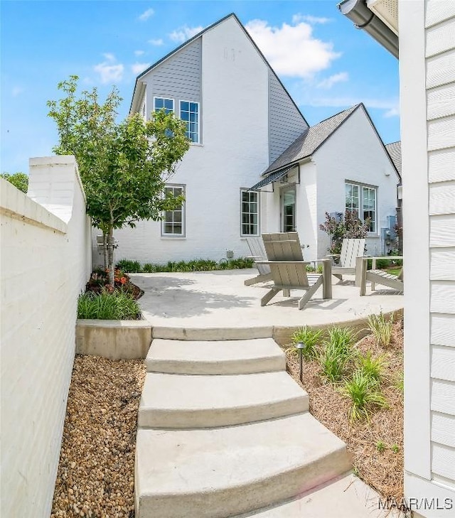 exterior space with a patio, fence, and stucco siding