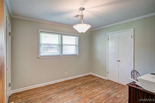 unfurnished dining area featuring crown molding, baseboards, visible vents, and light wood finished floors