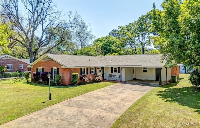 single story home featuring driveway, brick siding, fence, a front lawn, and an attached carport