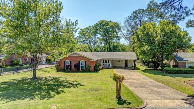 single story home featuring brick siding, fence, a front lawn, concrete driveway, and an attached carport