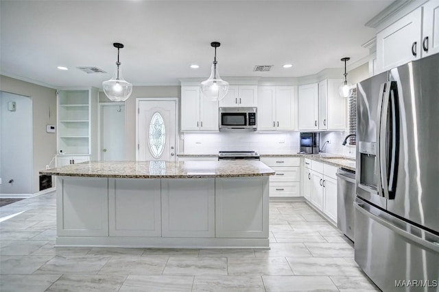 kitchen featuring visible vents, appliances with stainless steel finishes, a center island, a sink, and white cabinetry