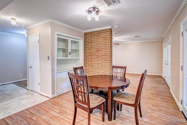 dining space with visible vents, baseboards, crown molding, and light wood-type flooring
