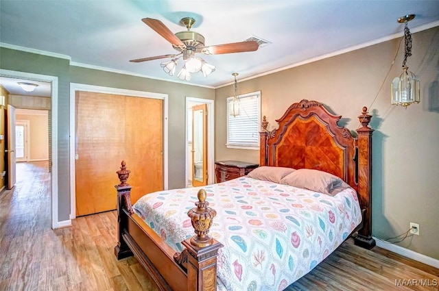 bedroom featuring crown molding, baseboards, visible vents, and light wood-type flooring