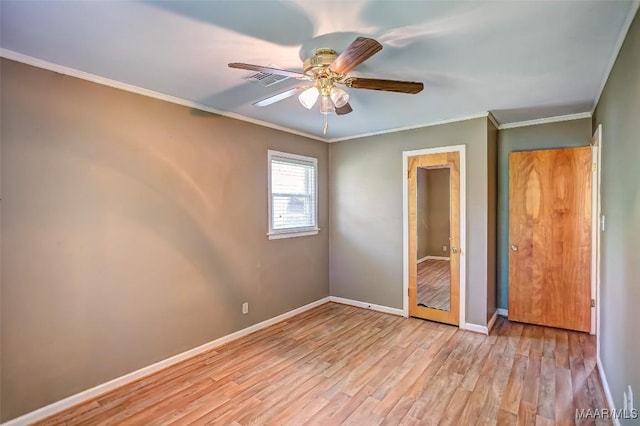 unfurnished bedroom featuring crown molding, visible vents, baseboards, light wood-style floors, and a ceiling fan