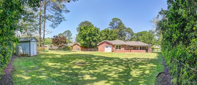 view of yard featuring an outdoor structure, a fenced backyard, and a shed