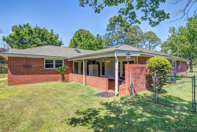 view of front of home with fence, a gate, and a front lawn