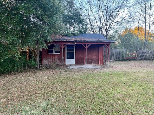 view of outbuilding featuring fence and a carport