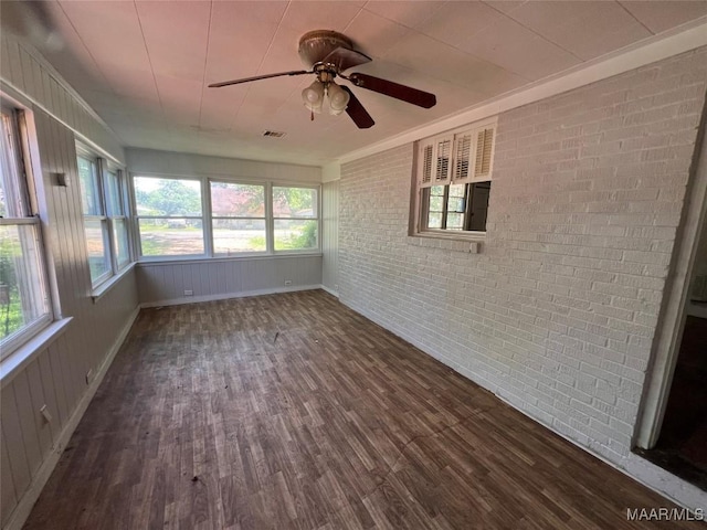 223 Mcdonald Ave, Selma, AL 36701 - unfurnished sunroom featuring wood finished floors, brick wall, and baseboards