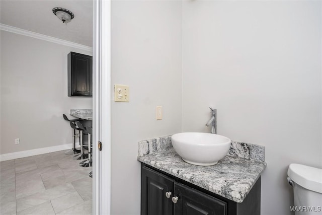 bathroom with crown molding, baseboards, toilet, and vanity