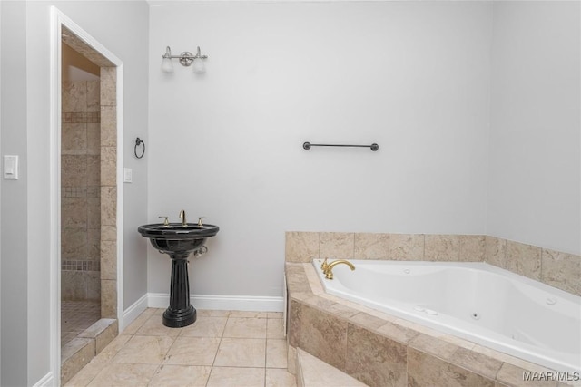 full bath featuring baseboards, tile patterned flooring, a tile shower, and a garden tub