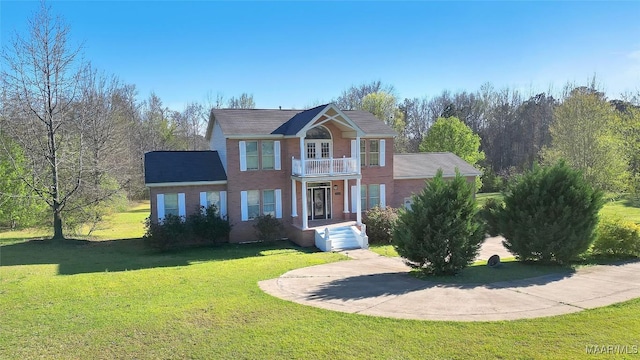 view of front of home featuring a front lawn and a balcony