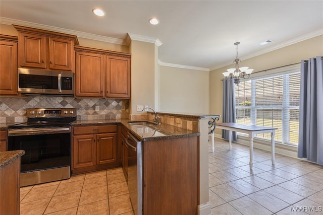 603 Coleman Way, Prattville, AL 36067 - kitchen featuring a peninsula, a sink, stainless steel appliances, brown cabinetry, and light tile patterned flooring