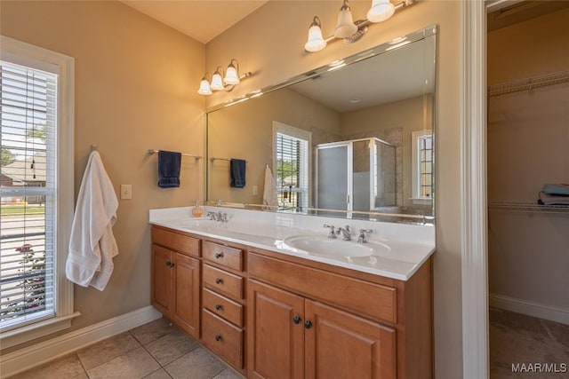 603 Coleman Way, Prattville, AL 36067 - bathroom with a stall shower, baseboards, a sink, double vanity, and a walk in closet
