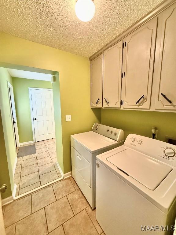 109 Lashley Dr, Selma, AL 36701 - laundry room featuring cabinet space, a textured ceiling, washer and dryer, light tile patterned floors, and baseboards